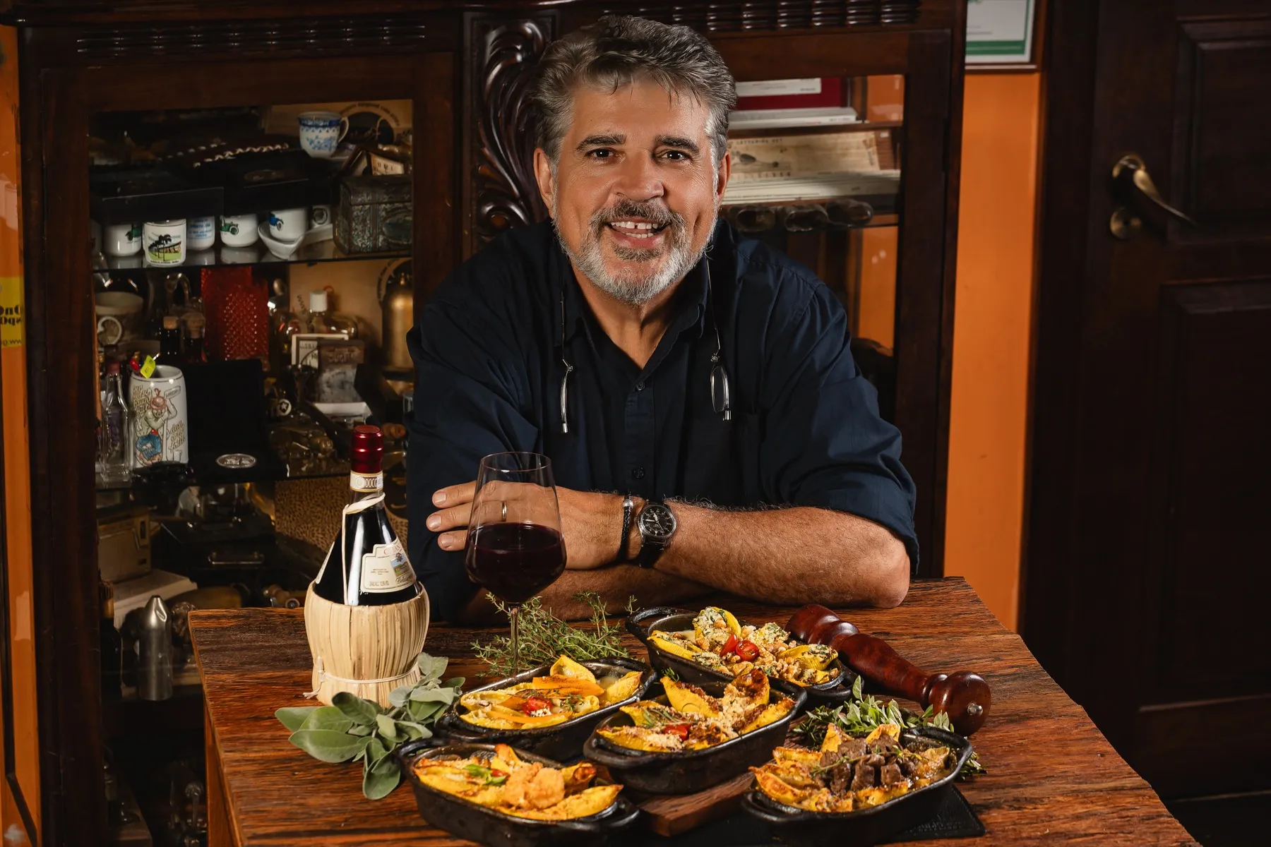 Délio Canabrava à mesa com os conchiglioni do festival e uma garrafa de vinho