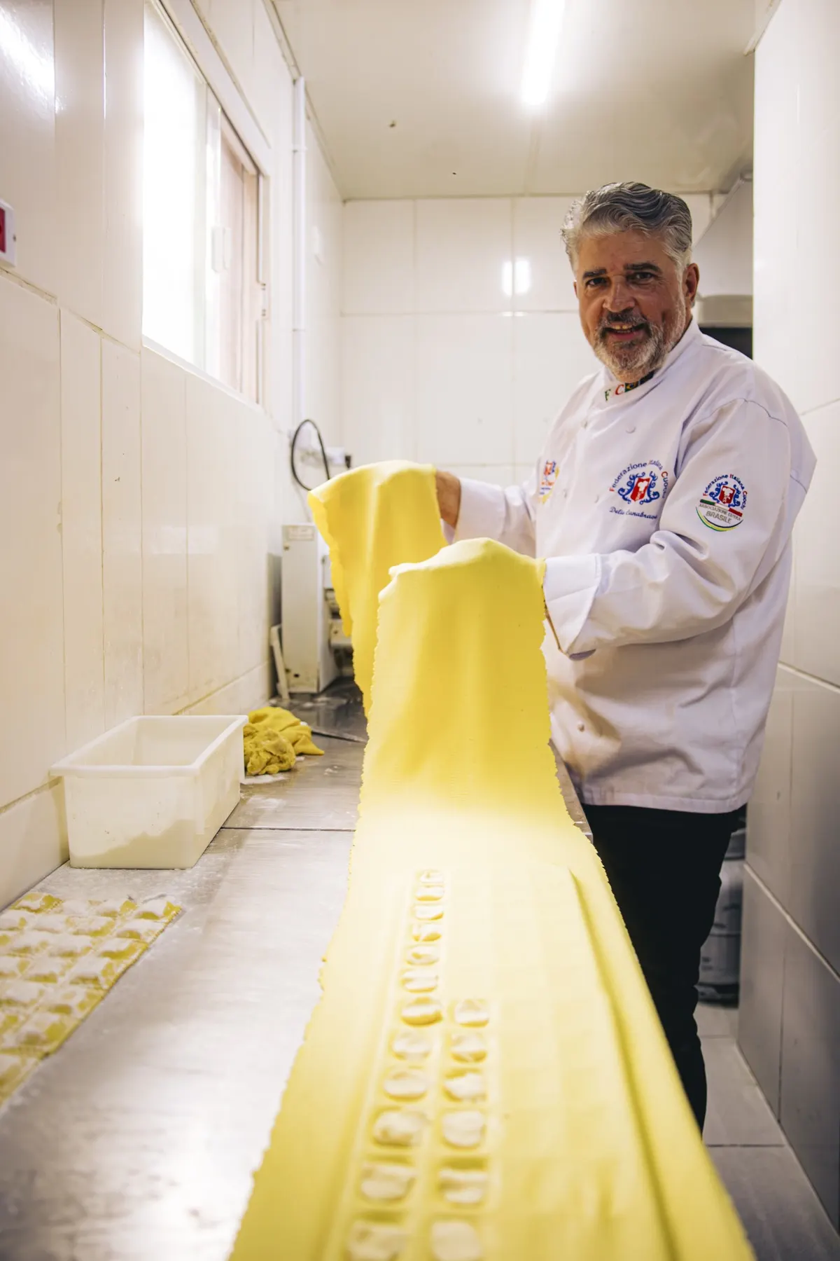 Délio Canabrava abrindo a folha de massa fresca na bancada da cozinha